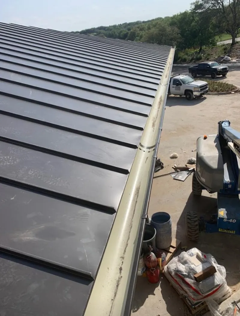 Standing seam panel and gutter detail on a metal roofing jobsite in Winchester